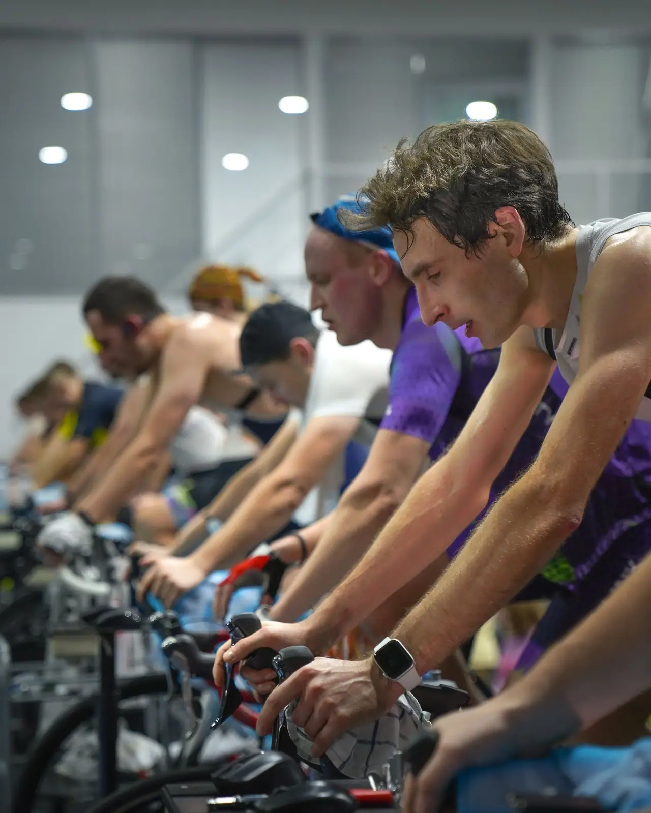 A row of riders working through an indoor cycling class